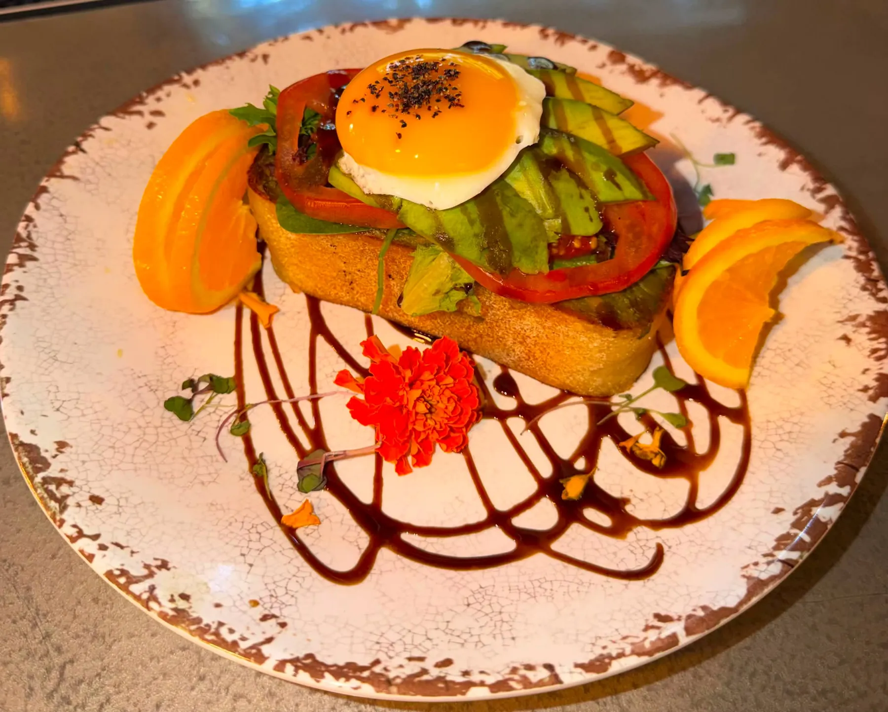 Avocado toast with egg, tomato and orange