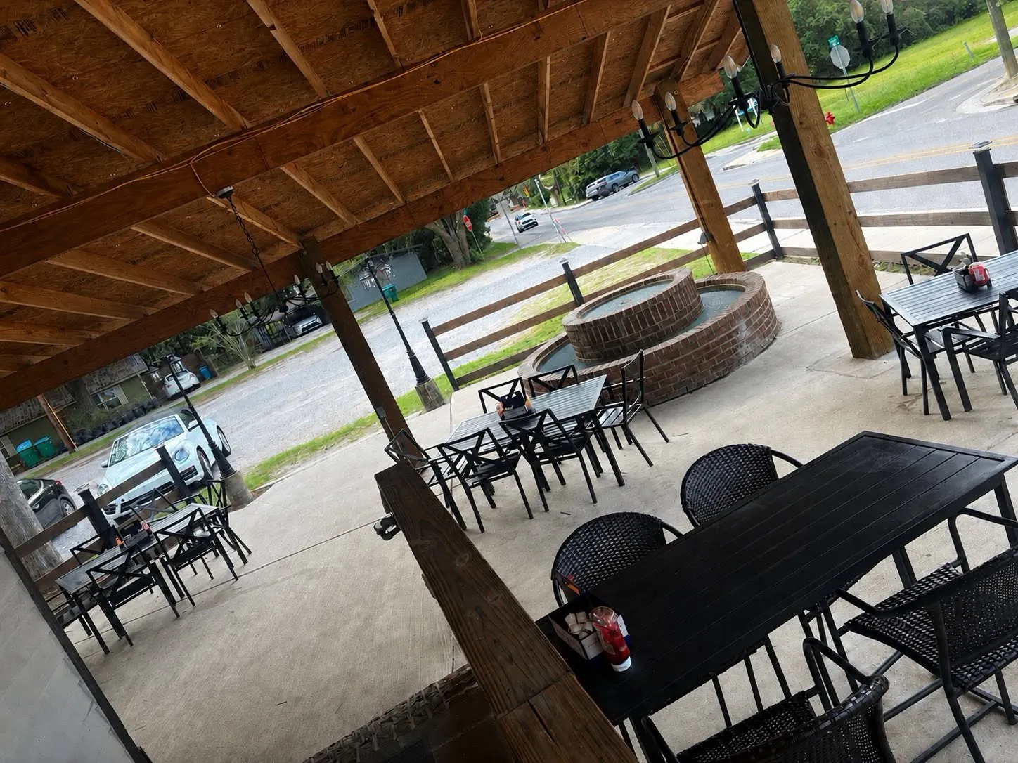 Covered patio with tables and the brick fire pit