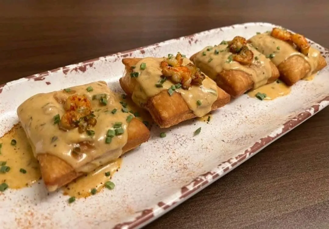 Fried beignet-style squares with creole cream sauce