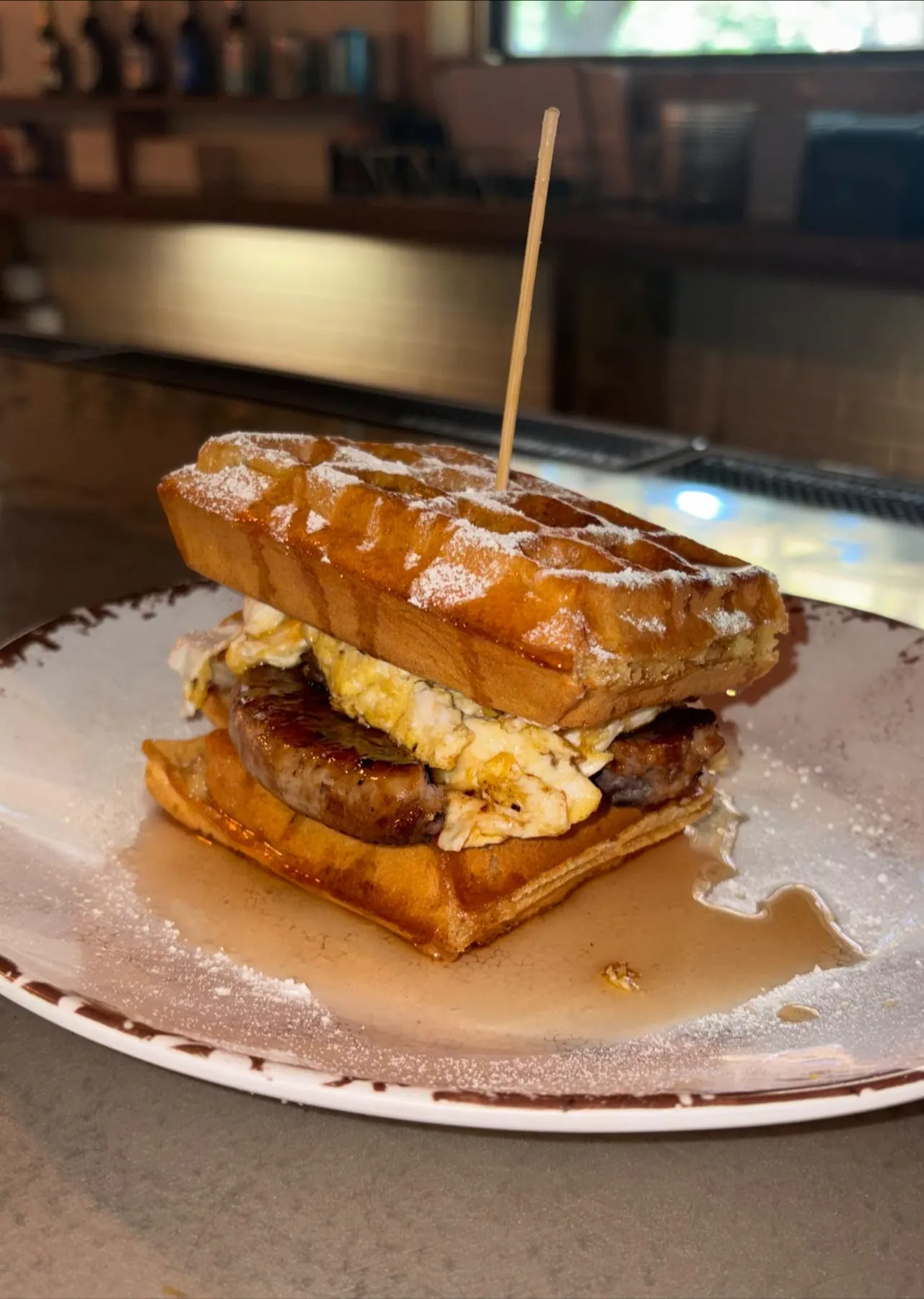 Waffle breakfast sandwich with sausage and egg
